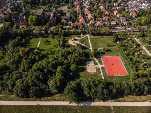 Polana Karłowicka - widok z lotu ptaka od strony północnej na plac zabaw, boisko sportowe, siłownię zewnętrzną oraz towarzyszące zadrzewienie.
