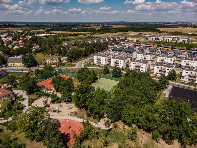 Skwer przy ul. Tymiankowej- widok z lotu ptaka na 3 boiska sportowe, plac zabaw i towarzyszącą zabudowę mieszkaniową.