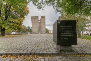 Skwer Sybiraków - widok na Pomnik Zesłańcom Sybiru we Wrocławiu, po obu stronach okazy drzew.