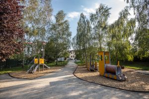 Skwer przy ul. Wałbrzyskiej- widok na plac zabaw, widoczna lokomotywa i zjeżdżalnia.