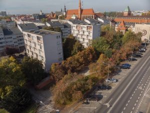 Skwer Jerzego Szmajdzińskiego - ujęcie z lotu ptaka na skwer, widoczne szpalery drzew i towarzysząca zabudowa mieszkaniowa.