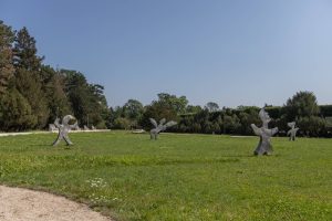 Park Szczytnicki- widok na plac zieleni, na pierwszym planie rzeźby Magdaleny Abakanowicz, na drugim planie grupy drzew.